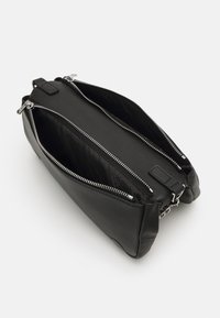 Black leather bag with two compartments, zippered closures, and a smooth texture. Features silver hardware and a simple design.