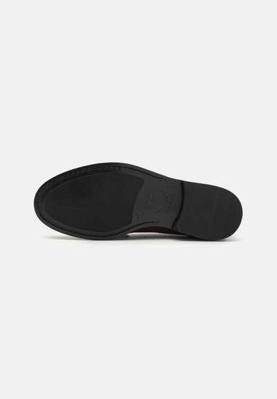 Musta nahkakengän pohja, jossa on sileä pinta, pyöreä muoto ja hienovarainen rakenne. Varustettu kohokuvioidulla brändäyksellä ja kerrostetulla kantapäädesignilla.