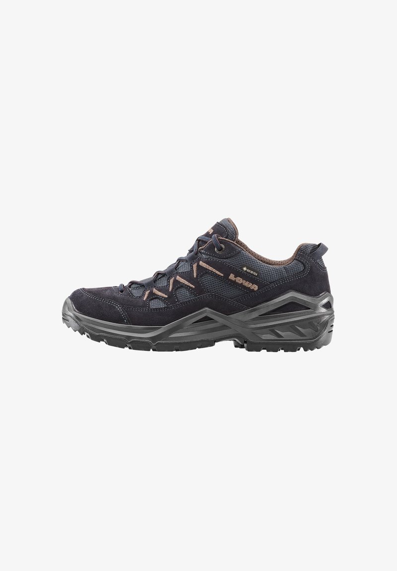 Scarpa da trekking con tomaia in suede e mesh di colore blu scuro, dettagli marroni, chiusura con lacci e suola in gomma nera testurizzata per una migliore aderenza.