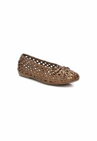 Bailarinas de bronce, tejidas a ganchillo, con un lazo decorativo en la punta y un diseño abierto para ventilación, que cuentan con una suela de goma flexible.