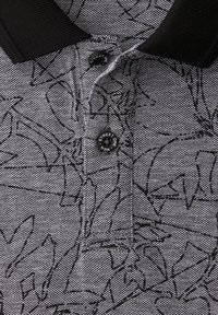 Grau-schwarzes Poloshirt mit Muster, schwarzem Kragen und zwei schwarzen Knöpfen, beschriftet mit "Men Street One".