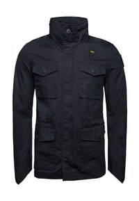 Czarna kurtka z wysokim kołnierzem, czterema przednimi kieszeniami, zatrzaskami i teksturowanym materiałem. Posiada łatę na ramieniu.