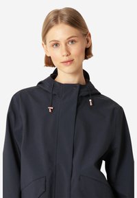 Granatowa, wodoodporna kurtka z kapturem, wyposażona w dwie przednie kieszenie, regulowane sznurki oraz akcenty w kolorze różowego złota.