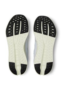 Shoe soles with a contrasting black and white design, featuring textured grip patterns and a structured shape for enhanced traction.