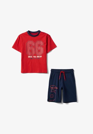 Camiseta roja de manga corta con el número 66 y el texto "Drive the Dream", combinada con pantalones cortos azul marino con el número 6 y cordón rojo.