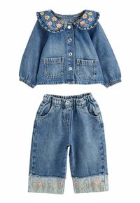 Denim-takkari ja housut. Takkarissa on röyhelöinen kukkakaulus ja kaksi etutaskua. Housuissa on joustava vyötärö ja kukkakirjailu lahkeissa.