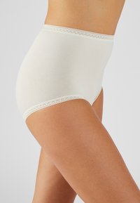 Bragas de algodón blancas de talle alto con un delicado borde de encaje a lo largo de la cinturilla, que presentan una textura suave y un diseño de cobertura completa.