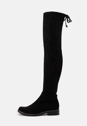 Bottes montantes en suède noir avec un bout arrondi, une semelle plate et une fermeture à nouer en haut pour un ajustement réglable. Texture lisse sur toute la surface.