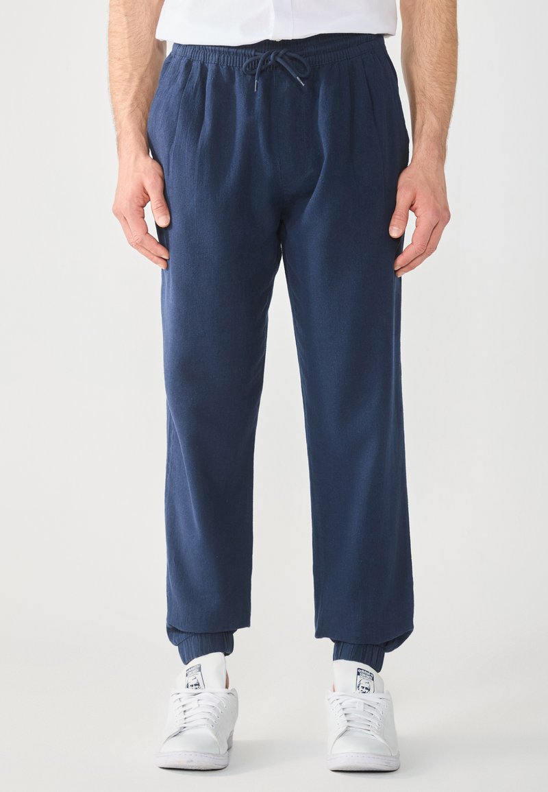Joggers bleu marine à coupe décontractée en tissu léger, dotés d'une taille élastique avec cordon de serrage ajustable et de poignets côtelés.