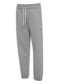 Szare spodnie dresowe z elastycznym pasem i kremowymi sznurkami, zwężane nogawki z elastycznymi ściągaczami oraz małe czarno-białe logo na lewym udzie.