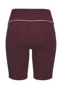 Pantaloni biker a vita alta, di un viola scuro, con dettagli in piping bianco lungo la cintura e le cuciture laterali, visti da dietro.