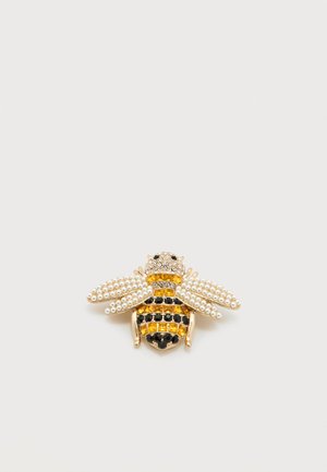 Καρφίτσα σε σχήμα μέλισσας με μεταλλικό χρώμα χρυσού, λευκά μαργαριτάρια, μαύρες και κίτρινες στρας, με λεπτομερή σχεδίαση φτερών και σώματος.