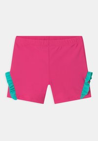 Shorts de bain roses avec une taille élastique. Dotés de volants turquoises sur les côtés. Fabrication en matériau lisse et léger.
