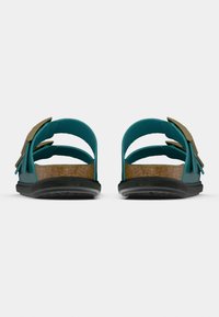 Τιρκουάζ σανδάλια με πάτο από φελλό, τρεις ρυθμιζόμενες λουρίδες και χρυσές μεταλλικές λεπτομέρειες. Μαύρη εξωτερική σόλα από καουτσούκ με υφή για καλύτερο κράτημα.