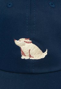 Námornícka modrá baseballová čiapka s vyšitým dizajnom psa v krémovej a hrdzavej farbe na prednej strane, vyrobená z textúrovanej bavlnenej tkaniny.