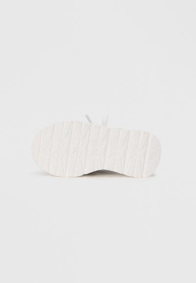 Λευκή σόλα αθλητικού παπουτσιού με υφή λαβής και διακριτική σήμανση. Μινιμαλιστικός σχεδιασμός με στρογγυλεμένες άκρες και λείο φινίρισμα.