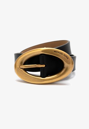 Zwarte leren riem met grote ovale antiek gouden gesp, gegraveerd met "Michael Kors," op een witte achtergrond.