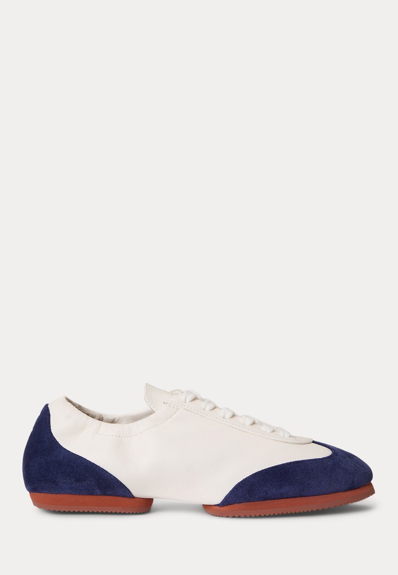 Λευκό sneaker χαμηλής κοπής με ναυτικό μπλε καστόρι στα δάχτυλα και τη φτέρνα, λευκά κορδόνια και καφέ λαστιχένια σόλα.