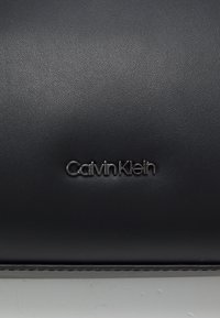 Calvin Klein VERTICAL LINES MESSENGER UNISEX - Taška cez plece - black