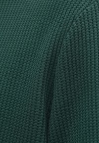 Υφασμα σε πράσινο χρώμα με υφή, διακοσμημένο με χαρακτηριστικό  σχέδιο βάφλας, μέτριας βαρύτητας και μαλακής υφής, ιδανικό για καθημερινή χρήση.