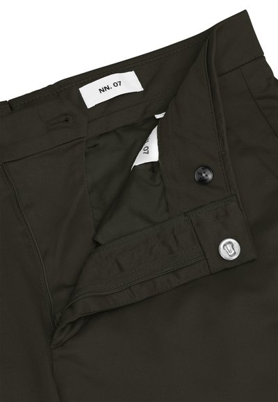 Ceinture de pantalon vert foncé avec bouton, fermeture à crochet métallique, boutonnière et étiquettes de marque blanches portant l'inscription "NN. 07".