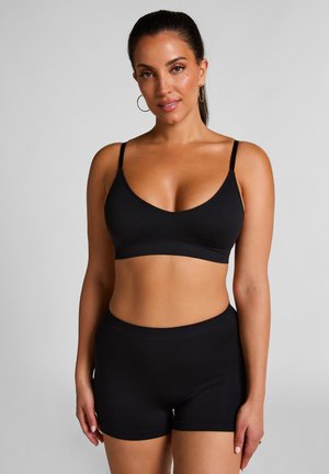 Zwarte bralette met dunne verstelbare bandjes en bijpassende high-waisted shorts. Gladde textuur, eenvoudig ontwerp zonder patronen of versieringen.