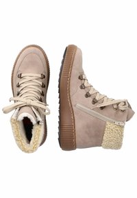 Bottes montantes beiges avec une finition en daim, un col en fausse fourrure texturé, un devant à lacets, une fermeture éclair sur le côté et une semelle en caoutchouc.