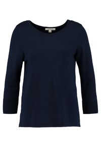 Laivastonsininen pitkähihaisen yläosa, jossa on pyöreä kaula-aukko, sileä pinta ja hihansuissa resorit. Valmistettu pehmeästä, joustavasta kankaasta.