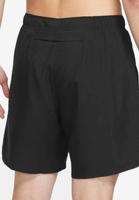 Czarne spodenki kąpielowe z elastycznym pasem, gładką fakturą i pojedynczą tylną kieszenią. Charakteryzują się luźnym krojem dla komfortu i swobody ruchów.