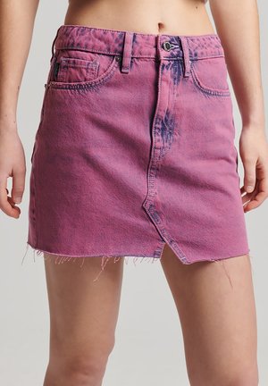 Mini-jupe en denim rose avec taille haute, dotée d'un ourlet effiloché et de poches avant. La décoloration usée ajoute un intérêt visuel.