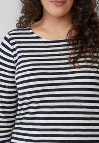 Gestreept lang mouwtshirt in marineblauw en wit. Heeft een ronde halslijn en zachte katoenen textuur met horizontale strepen van verschillende breedtes.