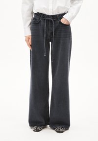 Wijde denimbroek in donker denim met een koord in de taille en voorzakken. Heeft een lichte vervaging en een relaxte pasvorm. Ontworpen voor comfort.