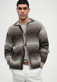 Sweter kardigan w gradientowych odcieniach szarości, z kołnierzykiem, guzikami z przodu i prążkowanymi mankietami. Miękka tekstura i luźny krój.