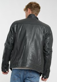 Herre sort læderjakke med en glat tekstur, der har en høj krave, syninger og knapmanchetter. Casual pasform med en lige kant.