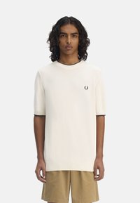 Maglione a maniche corte color crema, presenta un colletto a coste blu navy, un tessuto testurizzato e un piccolo logo ricamato sul lato sinistro del petto.
