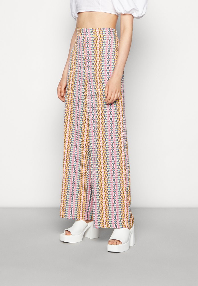 Vida byxor med hög midja, prydda med ett flerfärgat zigzag-mönster i rosa, gult och blått. Tillverkade av lättviktsmaterial.