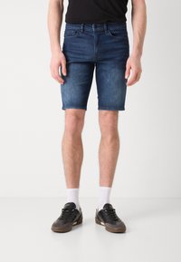 Shorts di jeans di colore blu scuro, lunghezza media fino alla coscia con una leggera scoloritura, orlo risvoltato, design a cinque tasche e chiusura con bottone standard.