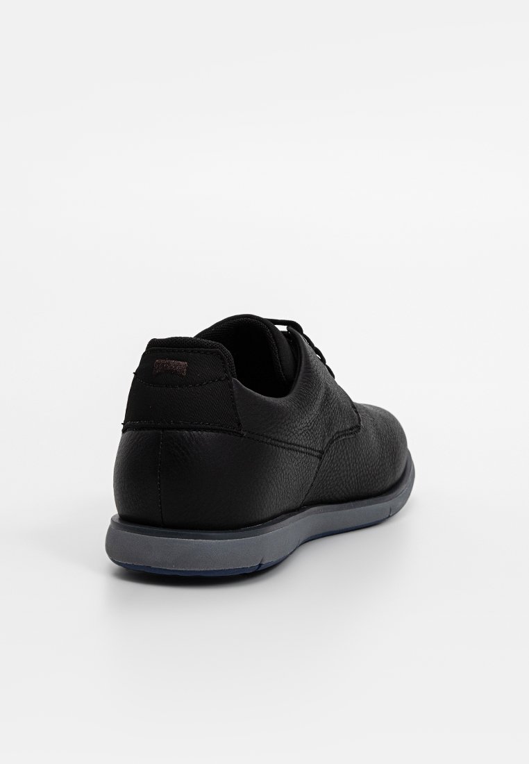 Czarne skórzane buty z fakturowanym wykończeniem, okrągłym noskiem i szarym gumowym podbiciem. Posiadają sznurowane zapięcie oraz subtelny detal z logo.