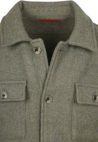 Olijfgroene wollen shirtjack met een puntige kraag, sluiting met knopen aan de voorkant en twee borstzakken met knoopflappen.