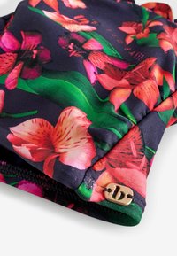 Ziedu raksta peldkostīms tumši zils, ar spilgti rozā un oranžiem ziediem, gludu audumu un zelta aksentu rāvējslēdzēja detaļā.