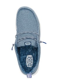 Zapatilla azul de tela sin cordones con superficie texturizada, cordones elásticos y suela blanca. El interior tiene un forro con estampado y un logo.