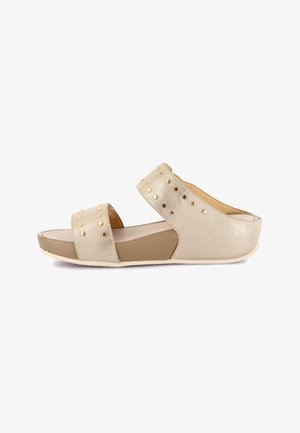Sandalo con zeppa beige con due ampi cinturini con borchie rotonde dorate e sottopiede imbottito.