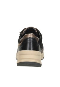 Schwarze Ledersneaker mit einer beige Mittelsohle, strukturierten Details und metallic Akzenten an der Ferse. Glatte und strukturierte Oberflächen sichtbar.