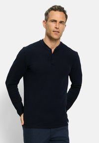 Marineblaues Langarm-Henley-Shirt aus strukturiertem Stoff, mit einem knöpfbaren Kragen und taillierten Ärmeln, im klassischen Schnitt gestaltet.
