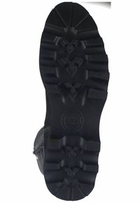 Suela de bota de goma negra con patrones de superficie profundamente marcados, que presenta un logotipo circular con "MH", proporcionando tracción y estabilidad en diversas superficies.