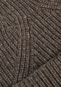 Tessuto lavorato a maglia marrone caratterizzato da un motivo testurizzato a coste, con leggere variazioni di tonalità e fibre fini e morbide diffuse in tutta la superficie.