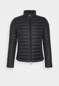 Zwarte gewatteerde jas met horizontaal stikpatroon, hoge kraag en voorrits. Bevat een oranje ritstrekkertje en logodetail op de mouw.