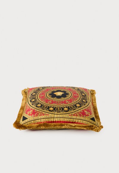 Διακοσμητικό τετράγωνο μαξιλάρι με κόκκινο και μαύρο μοτίβο, χρυσές λεπτομέρειες και φούντες περιμετρικά· κυρίαρχο γραφικό λιονταριού στο κέντρο.