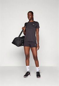 Must sportlik särk ja püksid, kombineeritud mustade ja roosade tossudega, valged sokid ja must spordikott. Lihtne, funktsionaalne disain.