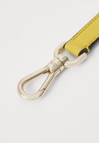 Curea din piele galbenă cu o suprafață texturată, cu un clip din metal de culoare aurie. Include accente de culoare maro închis pe margini.